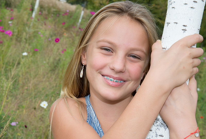 Young girl smiling in nature with braces