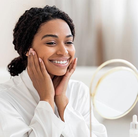 Woman gently holding her jaw while experiencing symptoms of TMJ disorder.