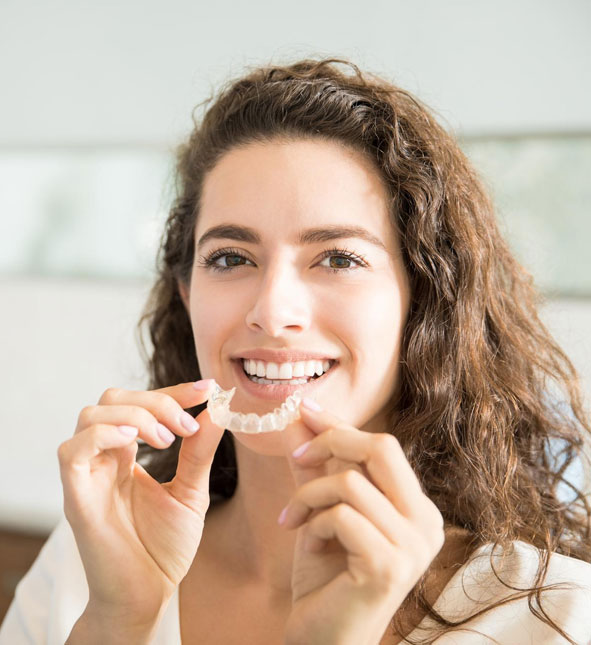Patient smiling while wearing clear aligners as part of a customized orthodontic treatment plan.