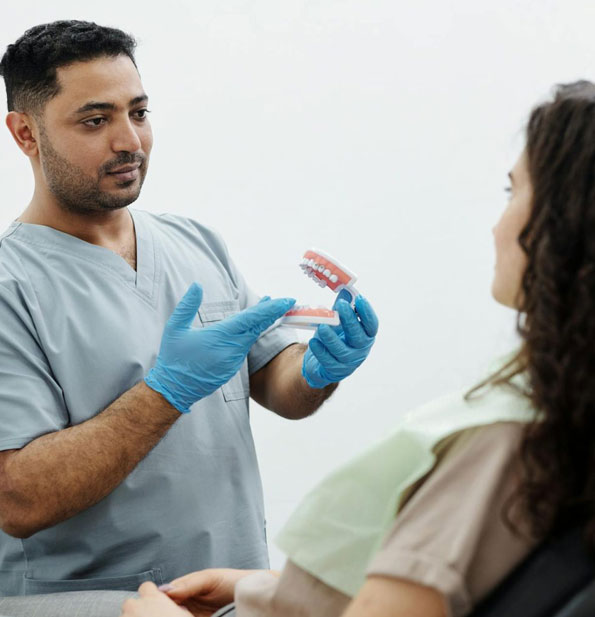 Orthodontist discussing jaw pain and TMJ treatment options with a patient during a consultation.